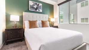 Quarto de hotel com uma cama grande, duas mesas de cabeceira, uma cabeceira e uma janela.
