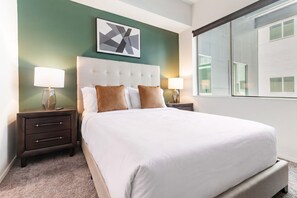 Ein Hotelzimmer mit einem großen Bett, zwei Nachttischen, einem Kopfteil und einem Fenster.