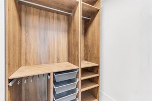 Ein Holzschrank mit offenen Regalen und Netzkörben.