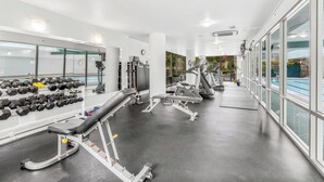 Un gimnasio moderno con cintas de correr, mancuernas y máquinas de pesas.