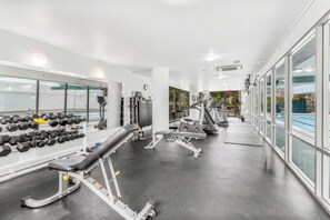Ein modernes Fitnessstudio mit Laufbändern, Kurzhanteln und Krafttrainingsgeräten.