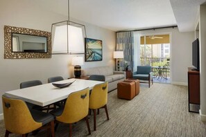 A hotel room with a dining area, a sofa, a balcony with a view, and a television. - Luxury Orlando Christmas getaway at Marriott Vacation Club near Disney! (Orlando)
