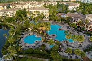 A resort with multiple swimming pools surrounded by palm trees and lounge areas. - Luxury Orlando Christmas getaway at Marriott Vacation Club near Disney! (Orlando)