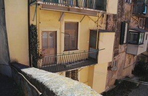 A multi-story building with balconies, a visible door, and a window. - At Cà du Grillu (Albisola Superiore)