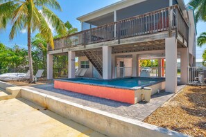 Ein zweistöckiges Gebäude mit Pool, Balkon und einer Treppe, die zum oberen Stock führt.