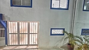A room with a large sliding glass door, a small window with a grid pattern, and a potted plant.