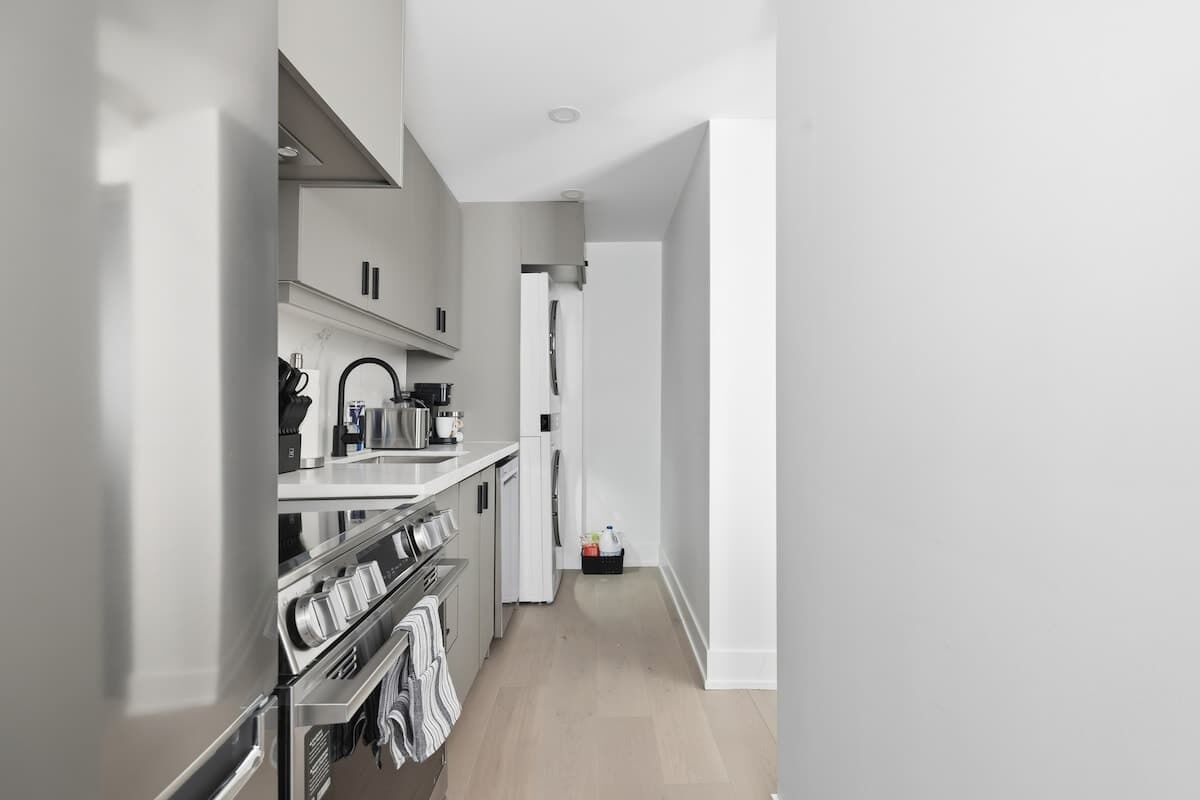 Eine moderne Küche mit Edelstahlgeräten, einem eingebauten Backofen und einer Arbeitsplatte mit Wasserkocher.