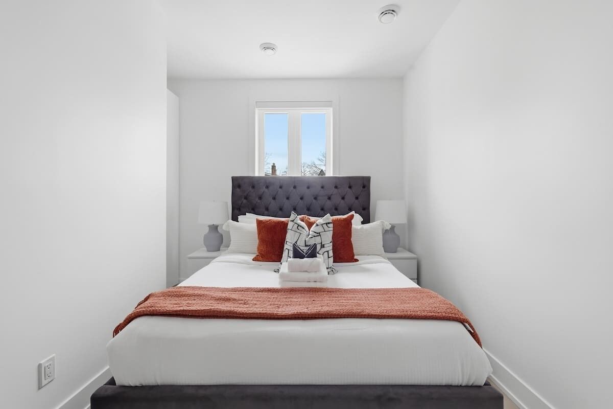A bedroom with a large bed, a window, and a view of the outside.
