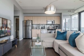 A modern apartment with a kitchen, dining area, and living room. - Premier Sub-Penthouse w Panoramic Views N Parking! (Toronto)