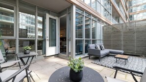Eine Terrasse im Freien mit einer Couch, Stühlen und einem Tisch.