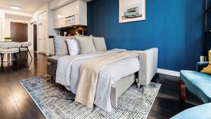 Ein modernes Schlafzimmer mit Bett, Essbereich und Küche.