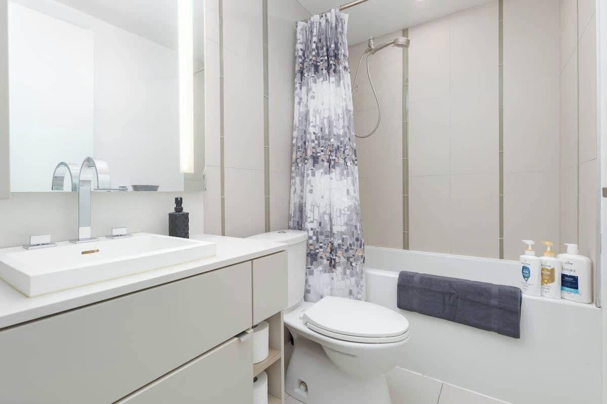 Ein modernes Badezimmer mit Waschbecken, Toilette und Duschvorhang.