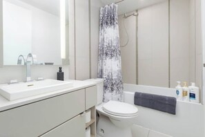 Ein modernes Badezimmer mit Waschbecken, Toilette und Duschvorhang.