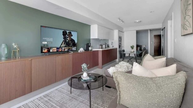 Una sala de estar moderna con un sofá, una mesa de centro y un televisor.