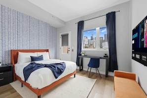Ein modernes Hotelzimmer mit Bett, Schreibtisch, Stuhl und einem Fernseher, der Fernsehkanäle zeigt.