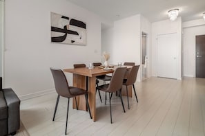 Ein Essbereich mit einem Holztisch, sechs Stühlen und einem modernen abstrakten Gemälde an der Wand.