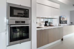 Eine moderne Küche mit integriertem Geschirrspüler, Backofen und Kaffeemaschine.