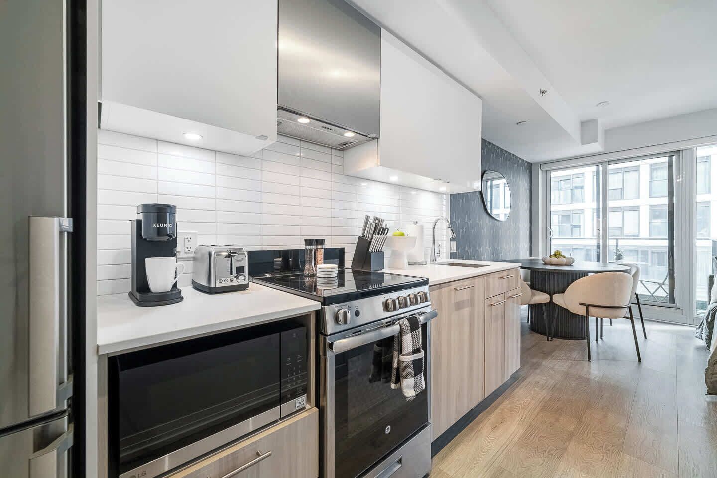 A modern kitchen with a built-in oven, a coffee maker, and a stove.