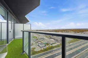 A modern building with large windows and a balcony with artificial grass. - Elevated Etobicoke Flat | Near Humber Bay (Toronto)