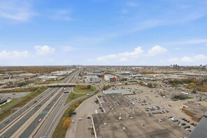 Un parking à plusieurs niveaux, avec plusieurs voies de circulation et une vaste zone industrielle en arrière-plan.