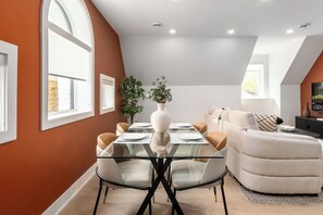 A dining area with a glass table, chairs, and a vase of flowers. - Free Parking! Dual King Suite | West End Gem  | Parking Available (Toronto)
