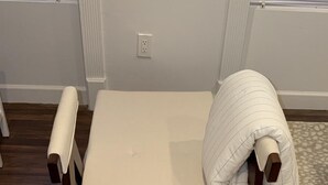 A small, single-bed room with a wooden headboard and a white mattress.