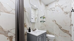 A bathroom with a white sink, a toilet, and a mirror.