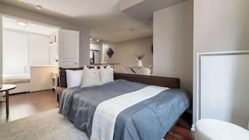 Une chambre à coucher comprenant un lit, une table de chevet et un petit espace bureau.