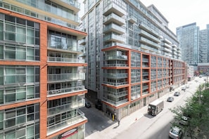 A multi-story building with a modern architectural design, featuring large windows and balconies. - Trendy Retreat Chic 2BR Suite Near City Sights (Toronto)