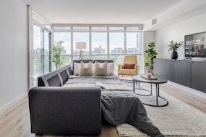 Ein modernes Wohnzimmer mit Sofa, Sessel und einem kleinen Tisch.
