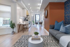 Un salon moderne comprenant un canapé, une table basse et un coin repas avec des chaises et une table.