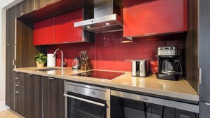 A modern kitchen with a built-in stove, oven, and coffee maker.