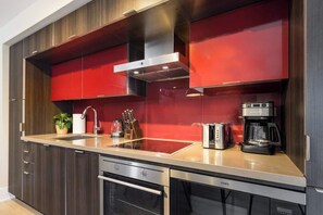 A modern kitchen with a built-in stove, oven, and coffee maker.