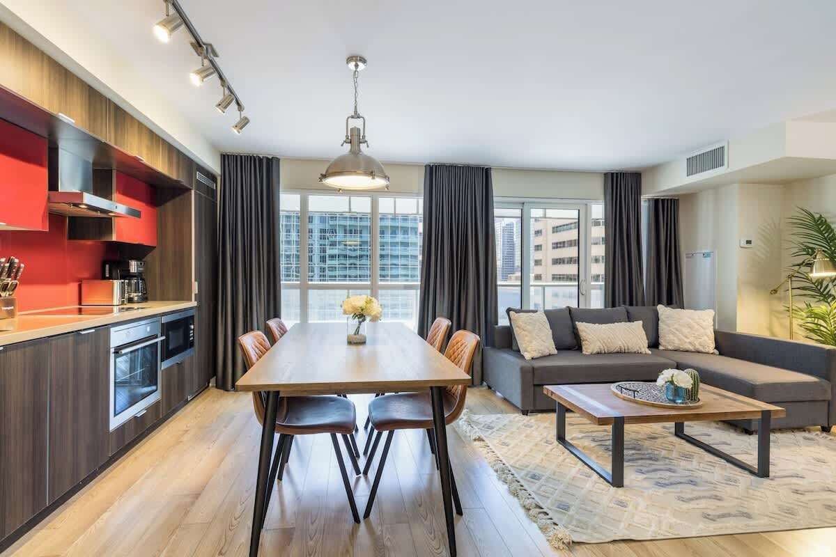 Un appartement moderne comprenant un coin repas, une cuisine et un salon.