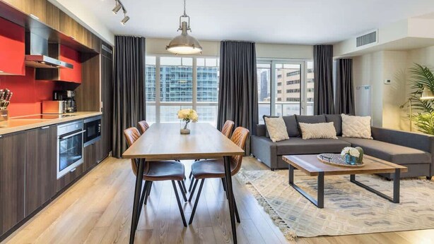 A modern apartment with a dining area, kitchen, and living room.