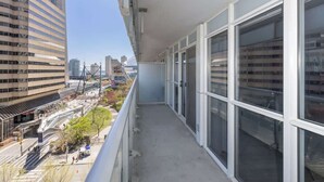 A balcony with a view of a cityscape, including buildings and a bridge.