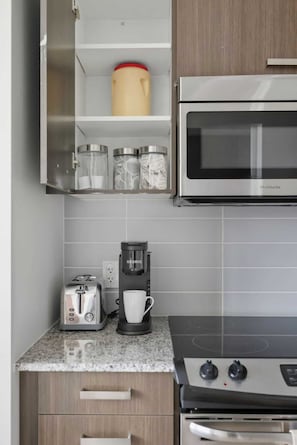Eine Küche mit Mikrowelle, Toaster, Kaffeemaschine und Herd.