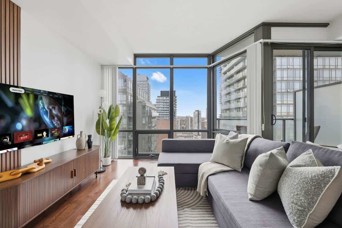 A modern living room with a large flat-screen TV, a sofa, and a coffee table.