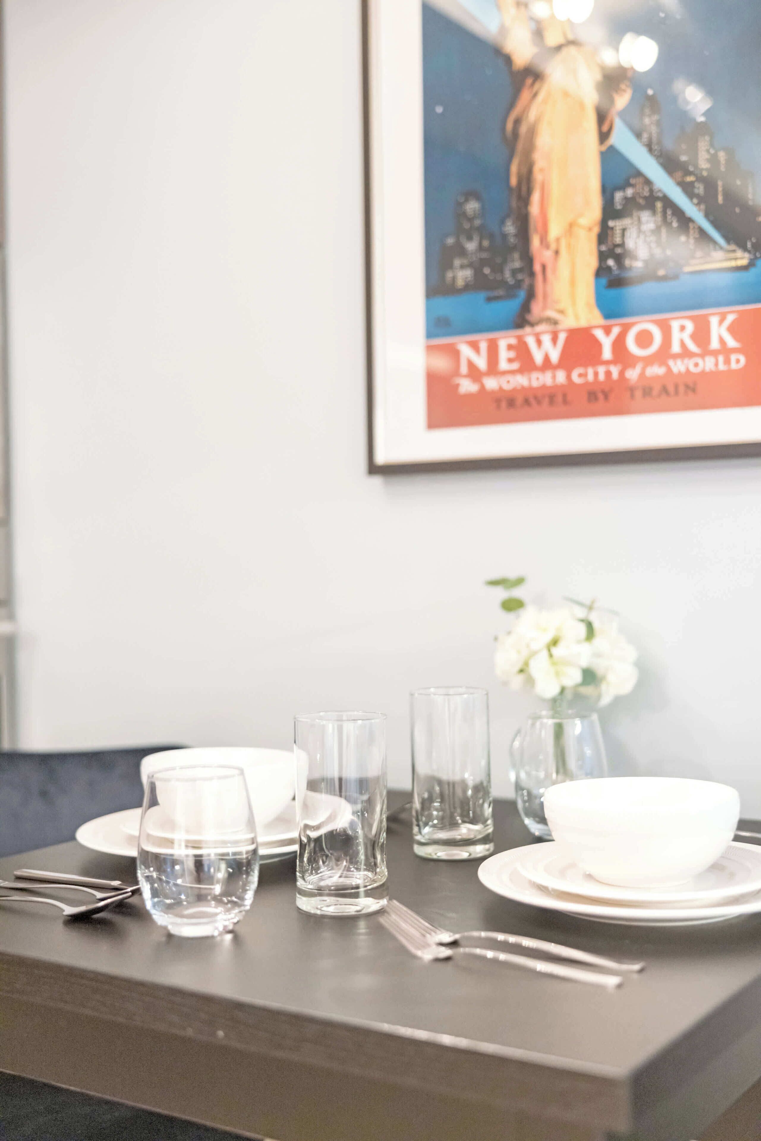 A dining table set with plates, glasses, and cutlery.