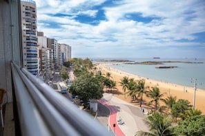Un paisatge urbà costaner amb una platja, edificis alts i un cel serè.