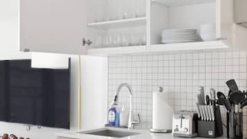 A modern kitchen with white cabinetry, a built-in dishwasher, a sink with a faucet, and a stove.
