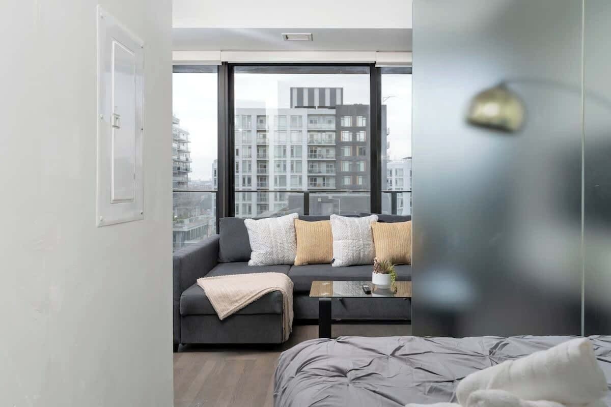 Un dormitorio moderno con una cama grande, un sofá y una mesita de centro.