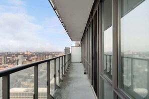A narrow corridor with large windows on one side, leading to a cityscape view.