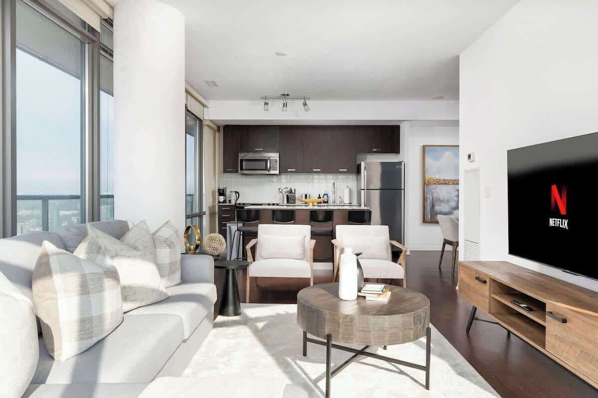 Een moderne woonkamer met een bank, salontafel en een flatscreen televisie.