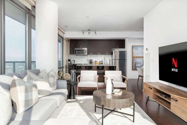 A modern living room with a sofa, coffee table, and a flat-screen TV.