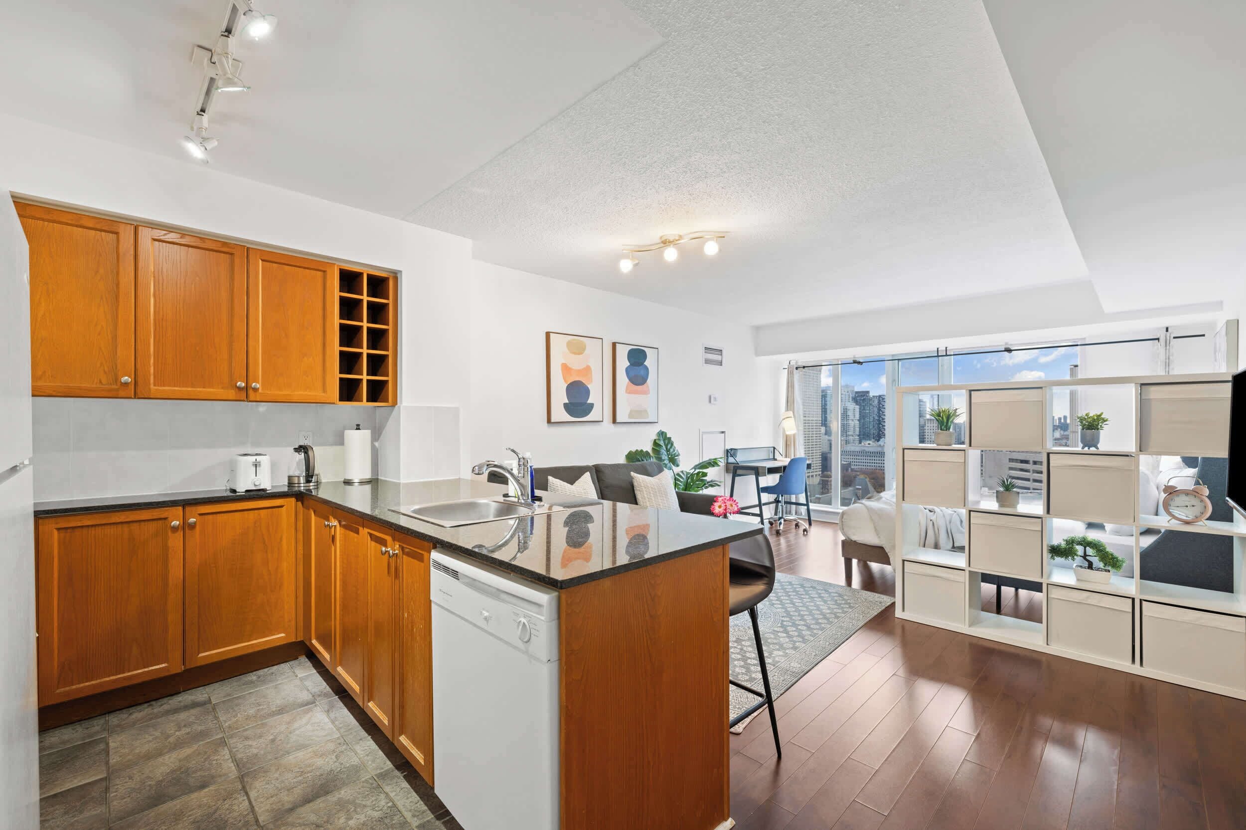 A modern kitchen with wooden cabinets, a built-in dishwasher, and a large island with a sink.