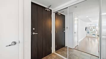 A hallway with a dark wooden door, a sliding glass door, and a tiled floor.