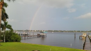 A waterfront property with a dock, boats, and a grassy area. - Historic 4-bedroom/2 bath house on St Lucie River-Big Water Views (Stuart)