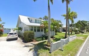 A single-story house with a white exterior, a garage, and a driveway. - Historic waterfront 4-bedroom, 2 bath house on St Lucie River-Big Water Views (Stuart)