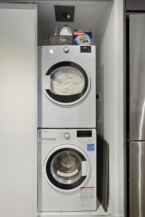 Una unidad compacta de lavadora y secadora con un panel de control, ubicada en un espacio reducido.